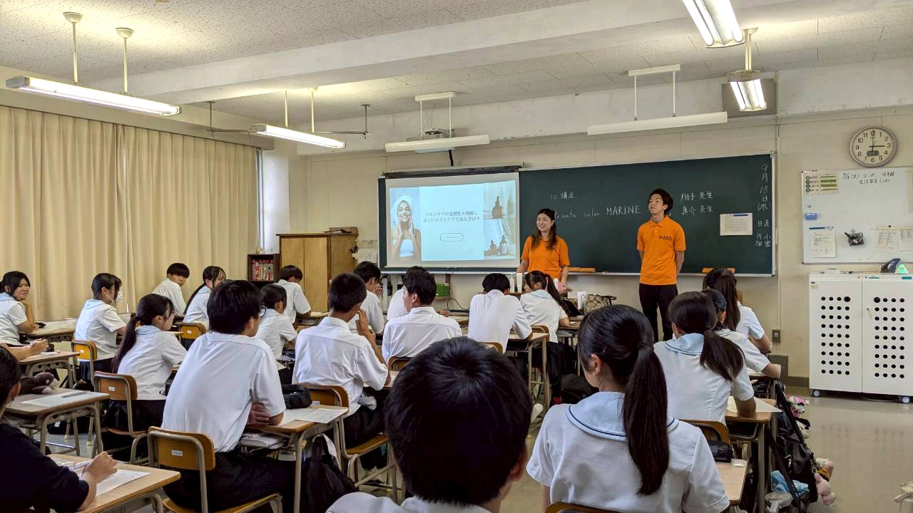 福津の仕事人で、光陵高校の壇上に立ち、講義を行う福津市商工会青年部の棚町夫妻。